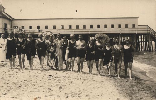 Laufende am Strand vor Umkleidekabinen