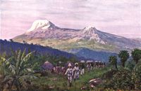 Der Kilimandscharo. Landschafts- und Kulturbild, im Vordergrunde Negerh�tten und Tr�gerkarawane der deutschen Schutztruppe.